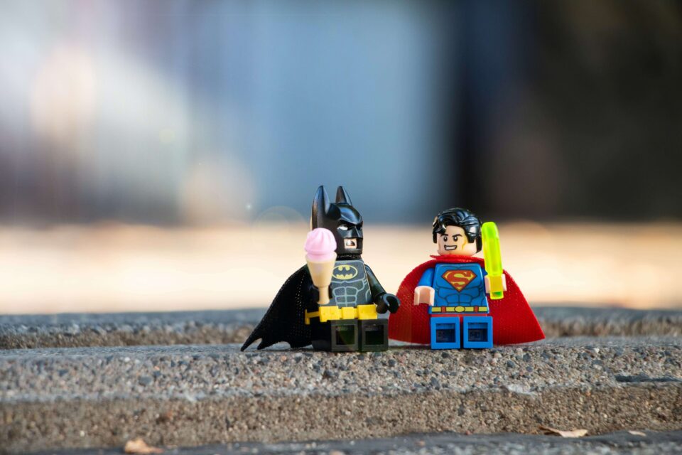 Due lego: uno di Batman con un gelato in mano e uno di superman con un ghiacciolo i mano